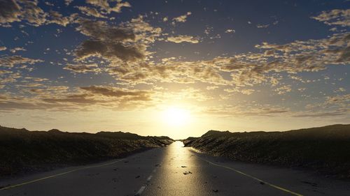 Road amidst trees against sky during sunset