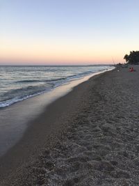Scenic view of beach against clear sky during sunset