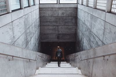 Man sitting on staircase against building