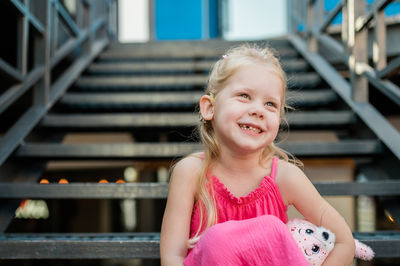 Portrait of young woman standing on staircase