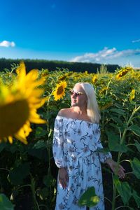 Woman standing in sunflower field