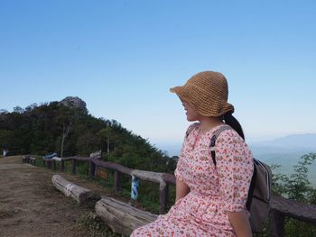 Rear view of woman looking at mountain against sky