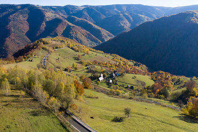 Aerial view of epic countryside road and autumn forest from above, drone point of view