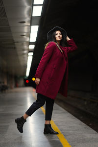 Full length of woman standing on road in winter