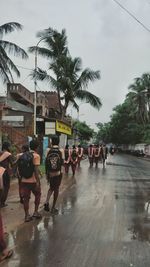 People on palm trees against sky