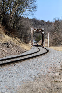 Railroad tracks by road against sky