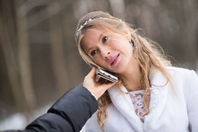 Cropped hand of man holding phone to girlfriend ear