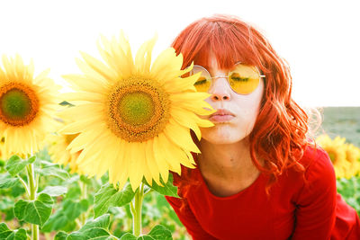 Close-up of beautiful woman wearing sunglasses by sunflower