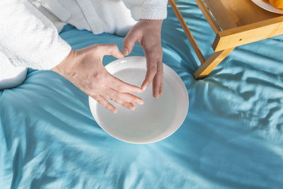 Bright oranges on a small coffee table and male hands