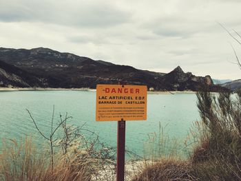 Close-up of warning sign at lake