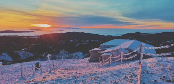 Scenic view of snow covered mountains against sky during sunset