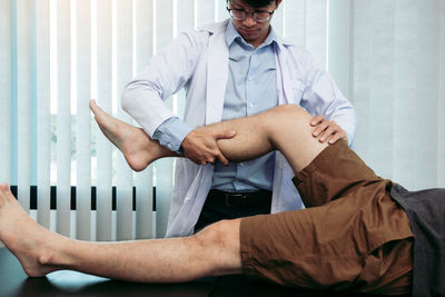 Portrait of doctor examining patient at home