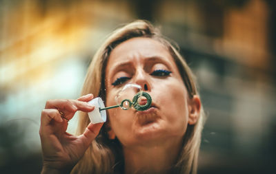 Portrait of mature woman blowing bubble 