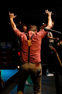 Rear view of men standing at music concert