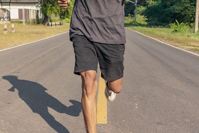 Low section of man standing on road