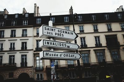 Low angle view of road sign against buildings in city