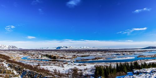 Scenic view of snowcapped mountains against blue sky