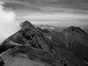 Scenic view of mountain range against cloudy sky