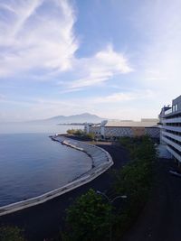 High angle view of city by sea against sky