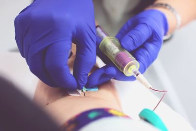 Cropped image of doctor giving iv drip to patient in hospital