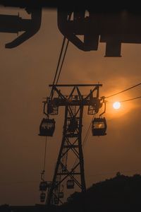 Overhead cable car against sky during sunset