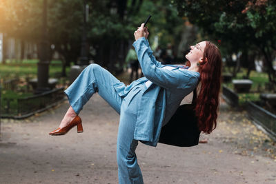 Rear view of woman standing on footpath