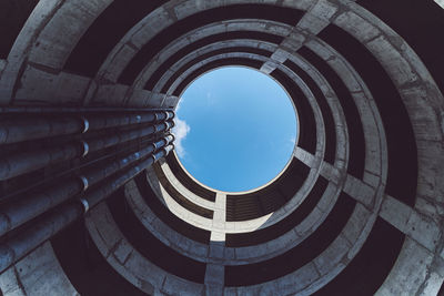 Low angle view of spiral building against blue sky