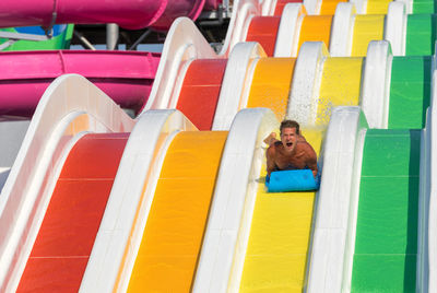 High angle view of man relaxing on multi colored seat