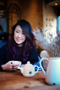 Portrait of smiling woman sitting at table
