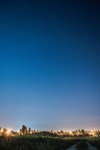 Scenic view of landscape against clear blue sky at night