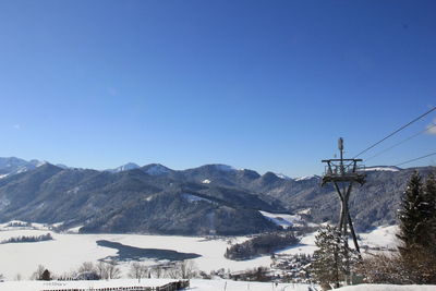 Overhead cable cars and mountains against clear blue sky