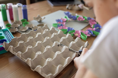 Kids create easter flower wreath in pastel colors using an upcycled egg trail. zero waste lifestyle