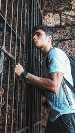 Portrait of young man standing against wall