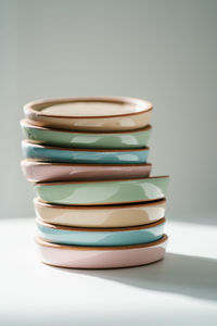 A large stack of ceramic cups in pastel colors.