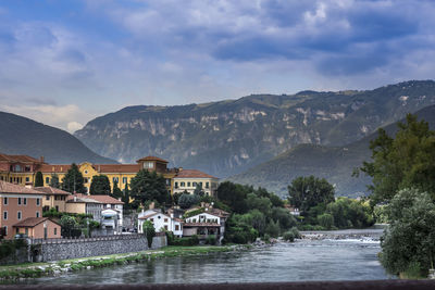 Houses by lake against sky in city