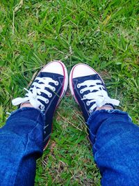 Low section of person wearing shoes on field