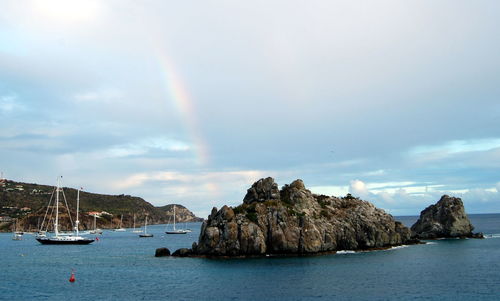 Scenic view of rainbow over sea against sky