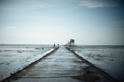 Pier over sea against sky during winter