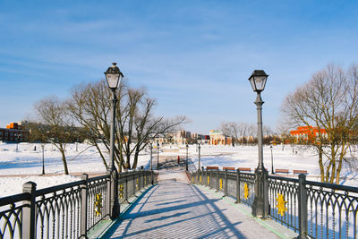 Street by snow covered city against sky