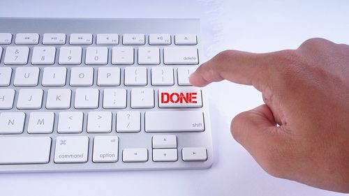 Close-up of person pointing at done button on keyboard