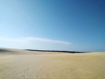 Scenic view of beach against blue sky