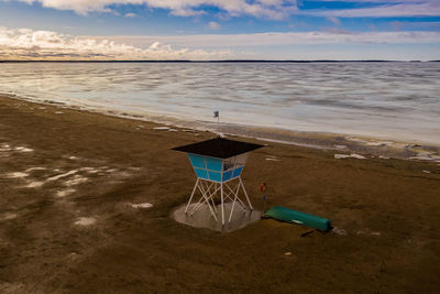 Lifeguard hut on beach against sky