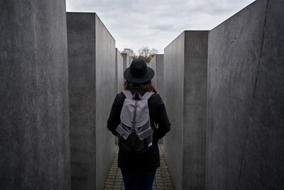 Rear view of woman standing against wall