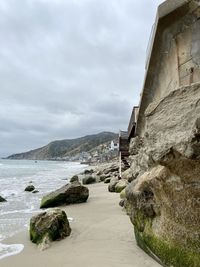 Scenic view of sea by buildings against sky