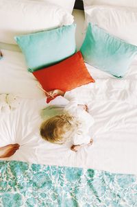 Directly above shot of girl sitting on bed at home