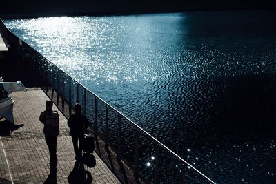 Silhouette men in illuminated water