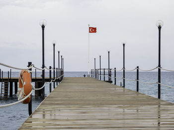 Deserted pontoon with orange life buoy,national flag of turkey. empty hotels, coronavirus covid-19.