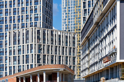 Active construction and facades of new apartment buildings in a residential area of the city block.