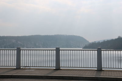 Scenic view of river by mountains against sky