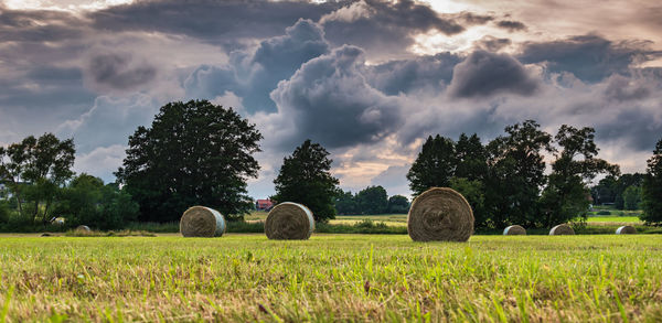 Hay bales on field against sky